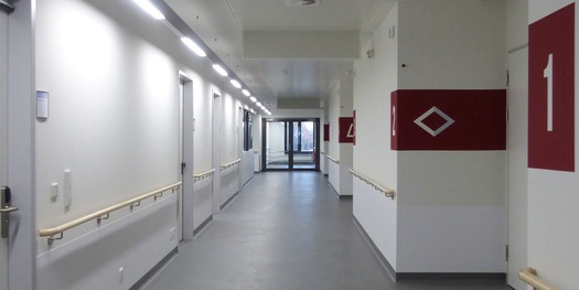 Blick in den Flur einer Patientenpflegestation im Obergeschoss mit Kennzeichnung der Zugänge zu den Patientenzimmern © 2019 Betrieb für Bau und Liegenschaften Mecklenburg-Vorpommern