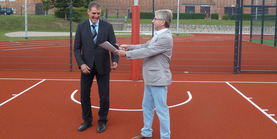 Der Leiter des SBL Neubrandenburg, Winfried Tasler, übergibt den Sportplatz an den kommissarischen Direktor Dr. Stefan Metzger. © 2021 SBL Neubrandenburg