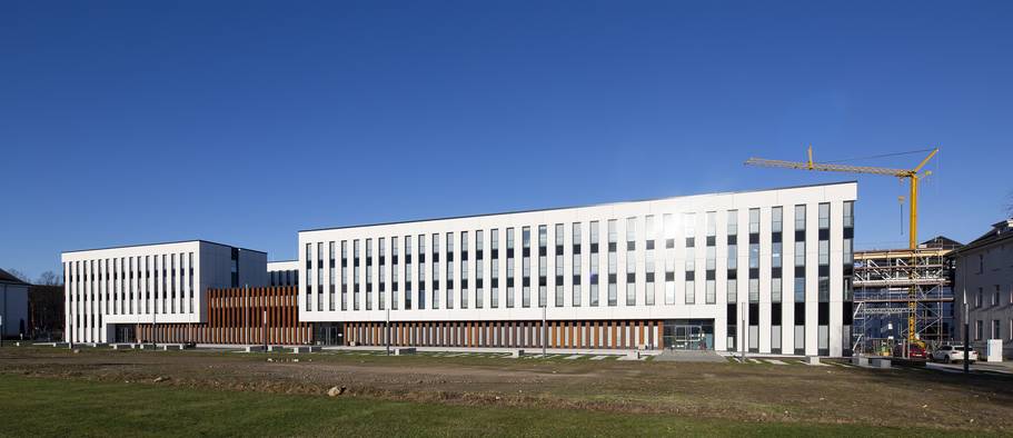 Der Neubau des MOC steht in der Bildmitte unter blauem Himmel. Ein Kran steht am rechten Bildrand. © 2022 Christian Hoffmann (SBL-MV, Finanzministerium M-V)