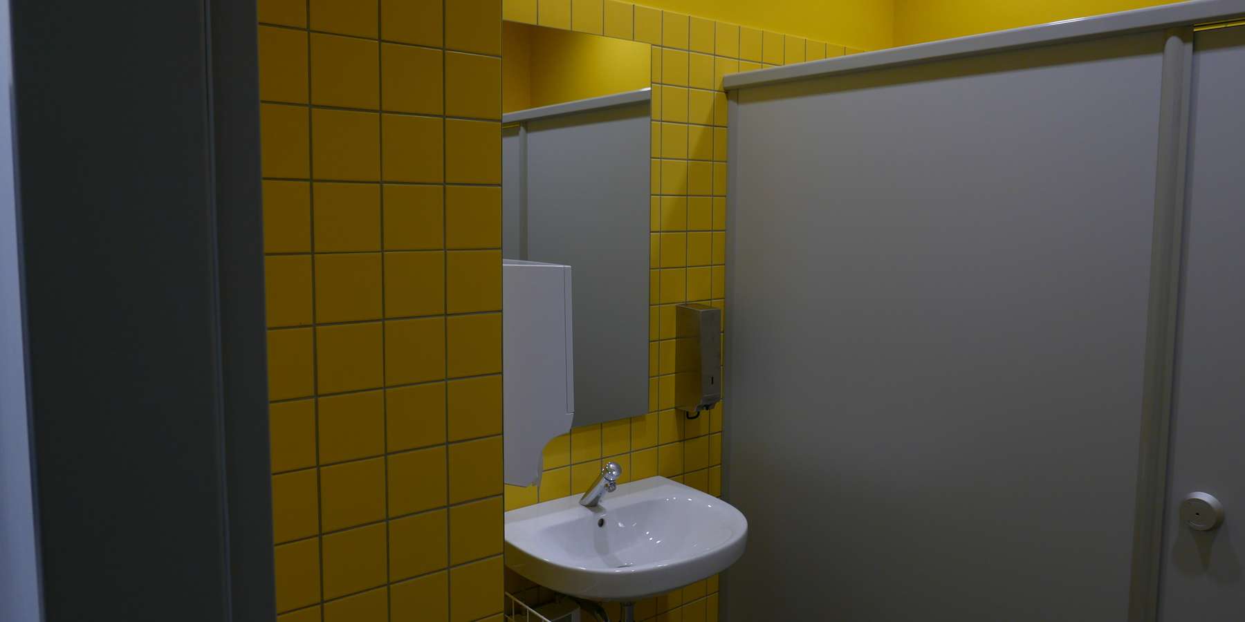 Das Farbschema zeigt die Geschossigkeit an, und wurde im ganzen Gebäude verwendet, z.B. in den WCs und Teeküchen - hier ein WC mit gelben Fliesen an den Wänden © J.Rott