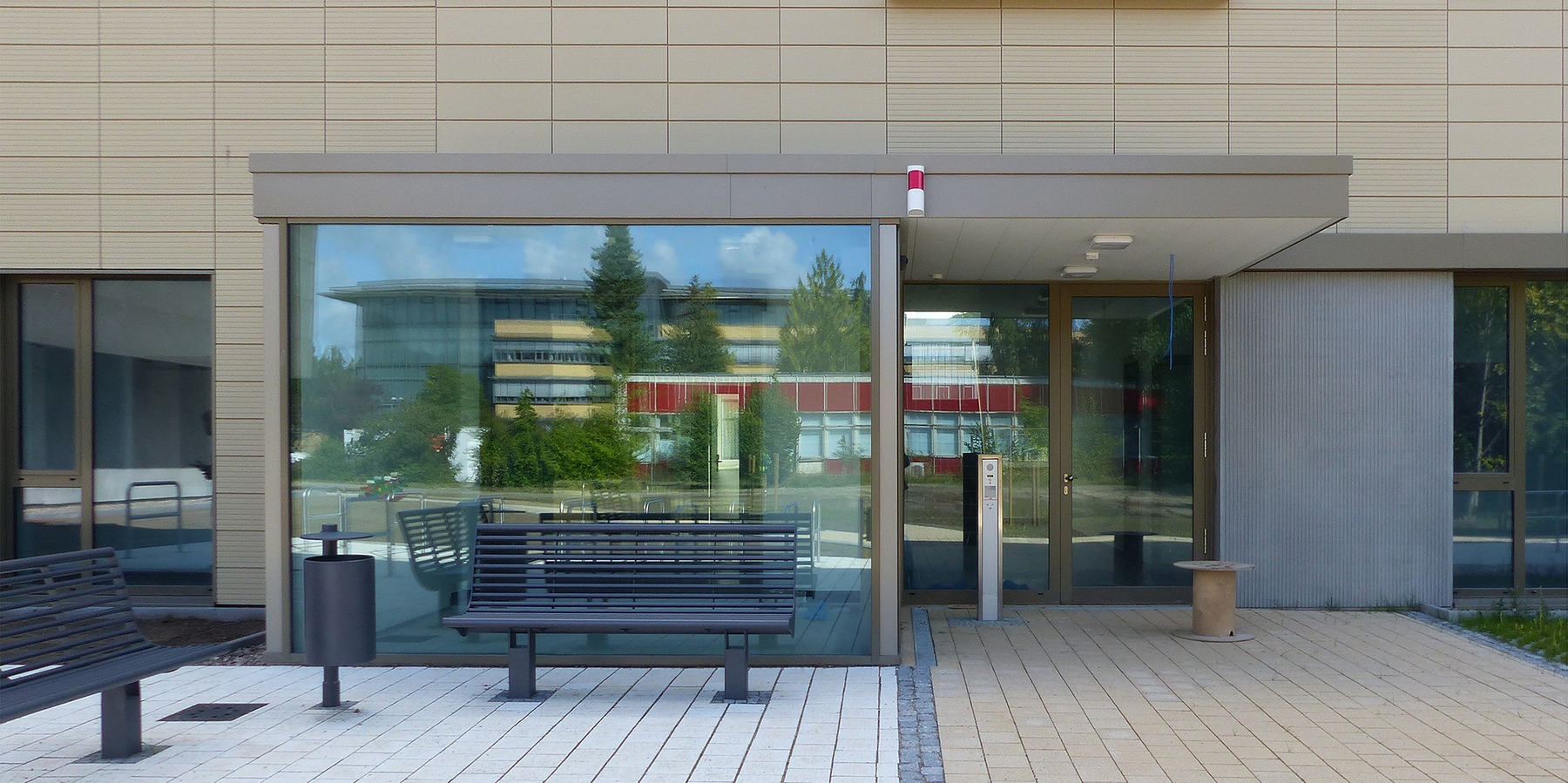 Haupteingang Seminar- und Verwaltungsgebäude - im Spiegelbild das gegenüberliegende alte Rechenzentrum mit roter Fassade © 2020 SBL Greifswald