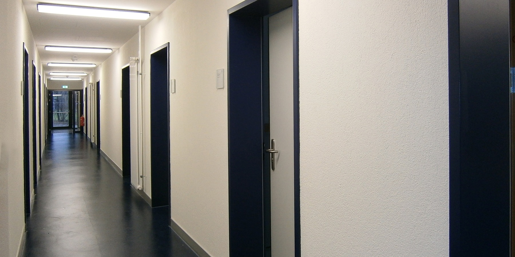 Flur im Erdgeschoss - hell und polizeitypisch - mit blauen Innentüren © 2013 Betrieb für Bau und Liegenschaften Mecklenburg-Vorpommern