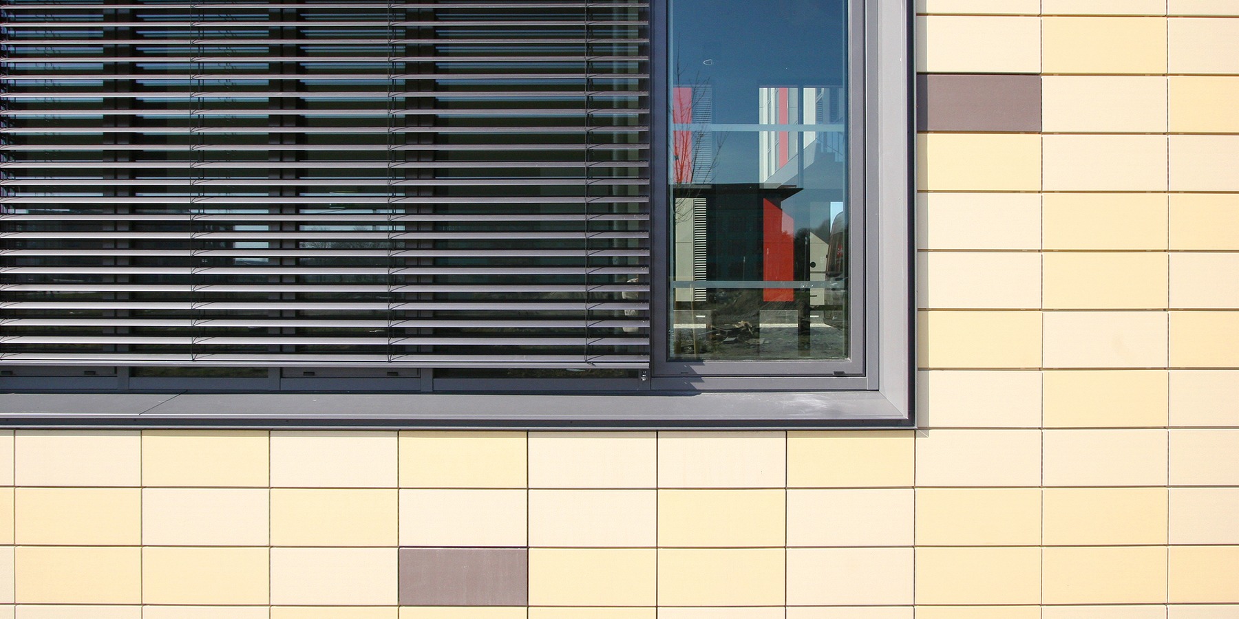 horizontal gegliederte Außenfassade mit schwarzen Fensterbändern und gelben Tonplatten © 2007 Betrieb für Bau und Liegenschaften MV