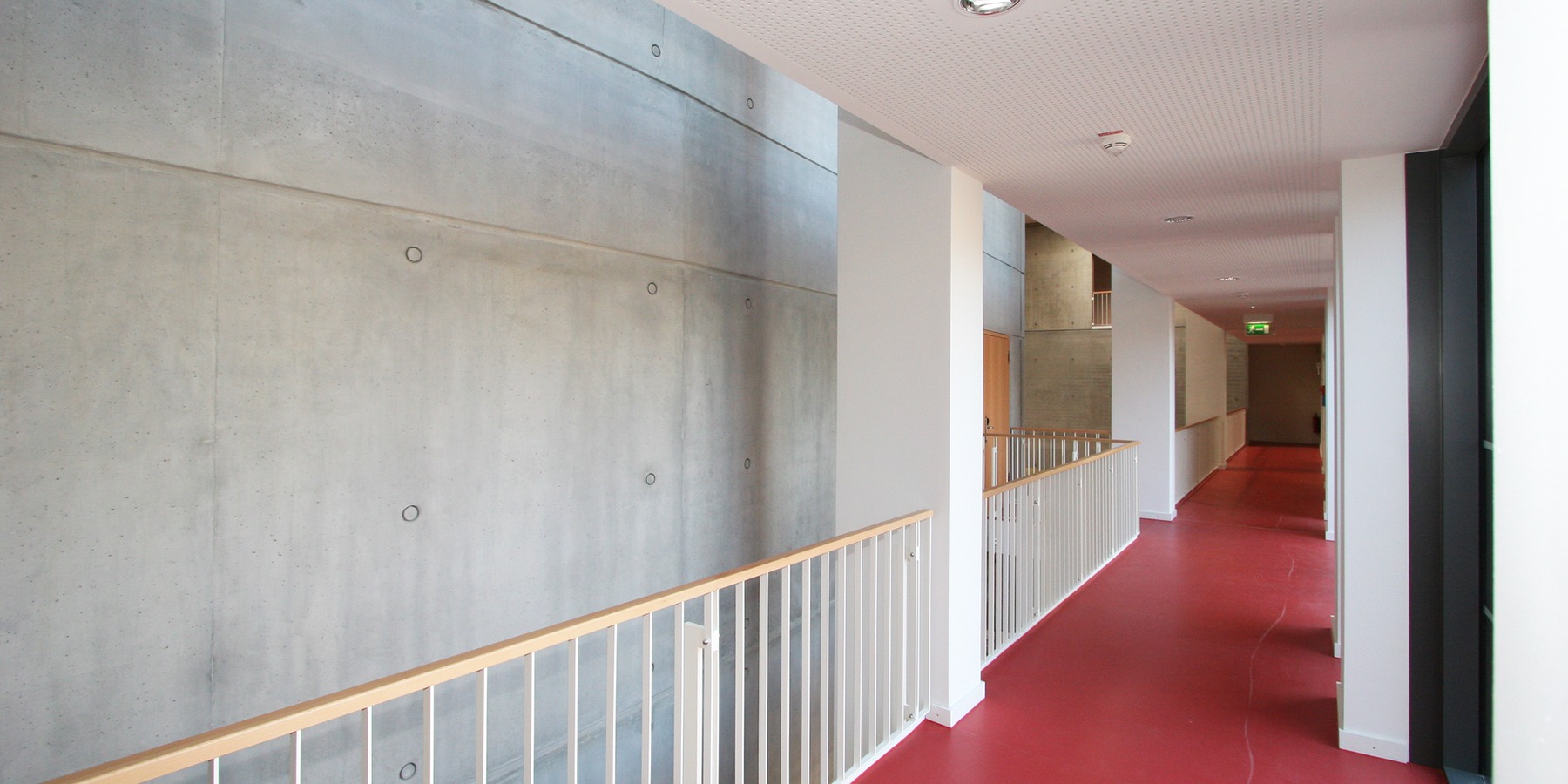 Wenige Materialien und Farben - Holz, Stahl, Sichtbeton, roter Fußboden, weiße Wände - bestimmen den Raumeindruck © 2007 Betrieb für Bau und Liegenschaften MV
