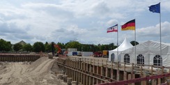 Blick auf das Baufeld mit Festzelt und Beflaggung - alles ist perfekt vorbereitet für die feierliche Grundsteinlegung © 2023 SBL Greifswald
