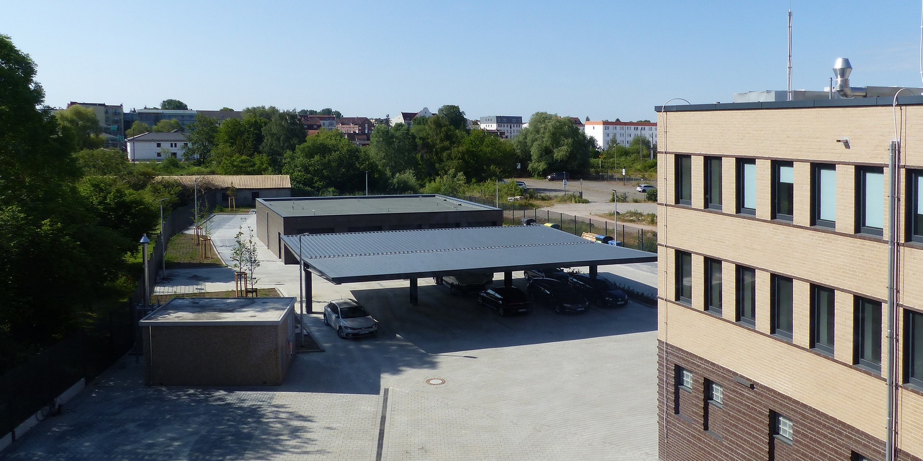 Blick auf das Hofgelände mit Carport- und Garagenkomplex für die Dienstfahrzeuge sowie Netzersatzanlage © 2023 SBL Greifswald