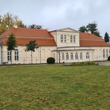 Blick auf die Orangerie mit bereits sanierter Fassade und neu eingedecktem Dach. © 2023 SBL Neubrandenburg