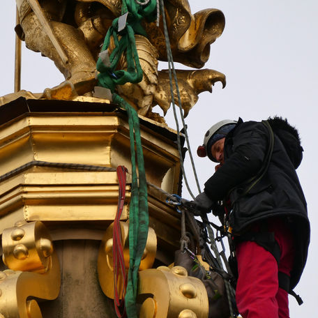 Ein Kletterer befestigt die Seile um den Erzengel. © 2024 SBL Schwerin
