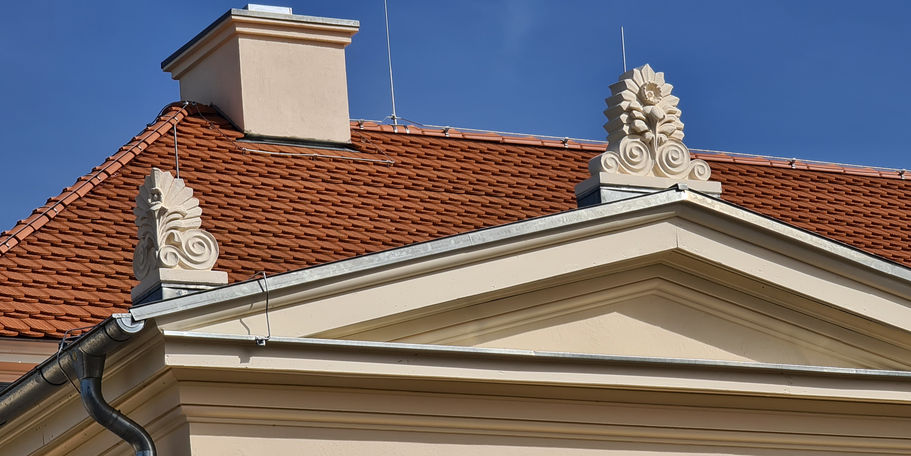 Blick auf die wieder ergänzten Akroterien und den Schornstein als Zierschornsteine auf dem Dach. © 2024 SBL Neubrandenburg