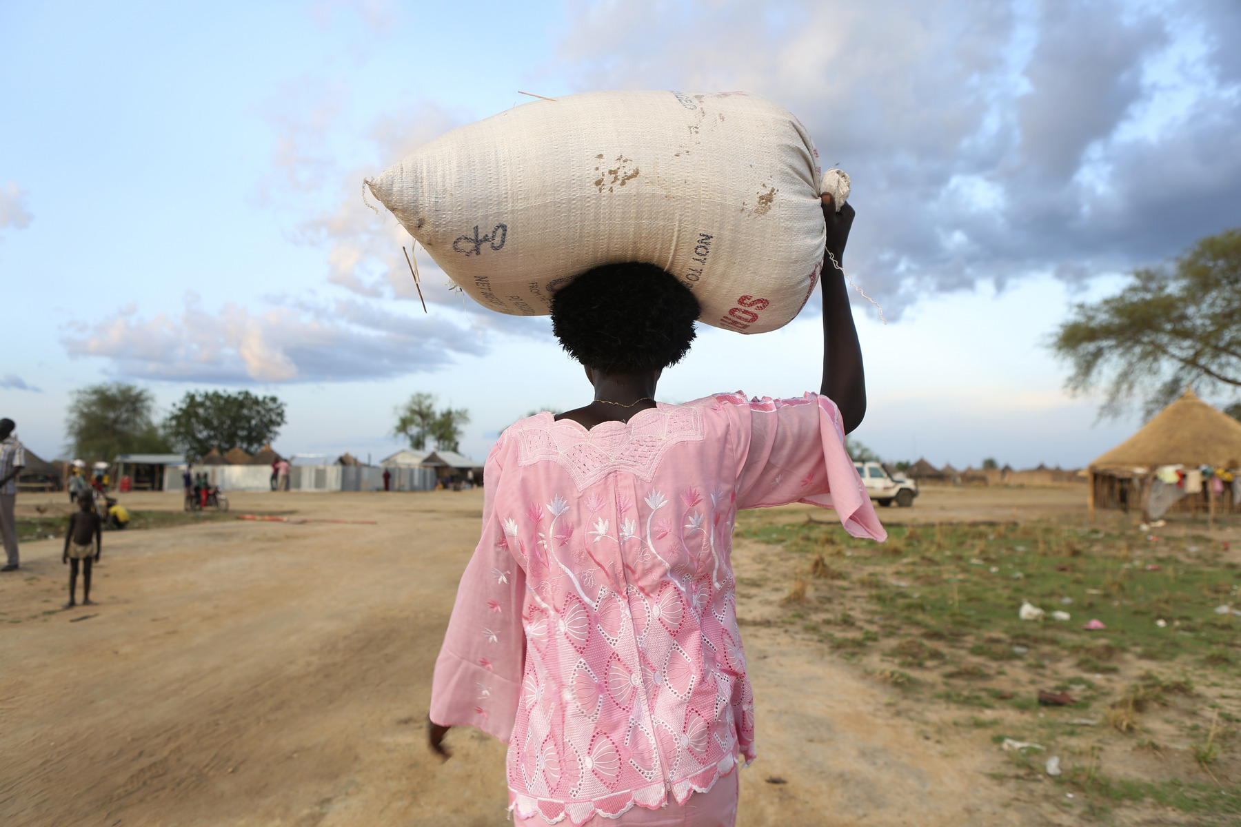 Jonglei, Südsudan: Eine Frau trägt einen gefüllten Erntesack in ihr Dorf.