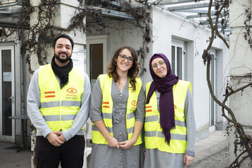 Drei Helfer*innen des Vereins Rahma Austria posieren lächelnd für die Kamera.