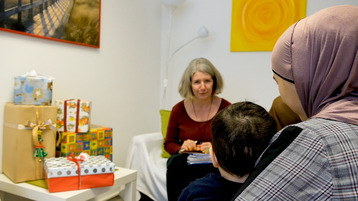 Eine Mutter sitzt mit ihrem Kind auf dem Schoß einer Beraterin von Aktion Leben gegenüber. Eine Mutter sitzt mit ihrem Kind auf dem Schoß einer Beraterin von Aktion Leben gegenüber.