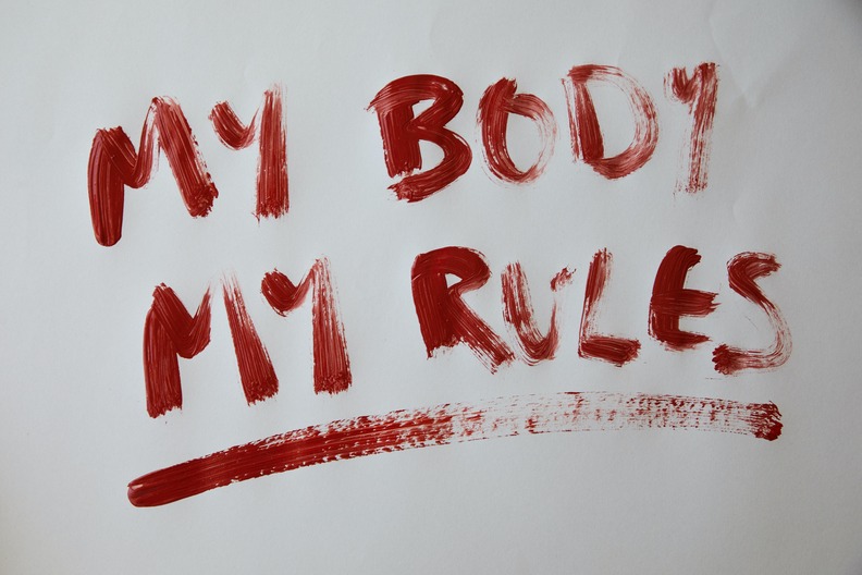 Weiße Wand mit roter Aufschrift "My Body, my rules"