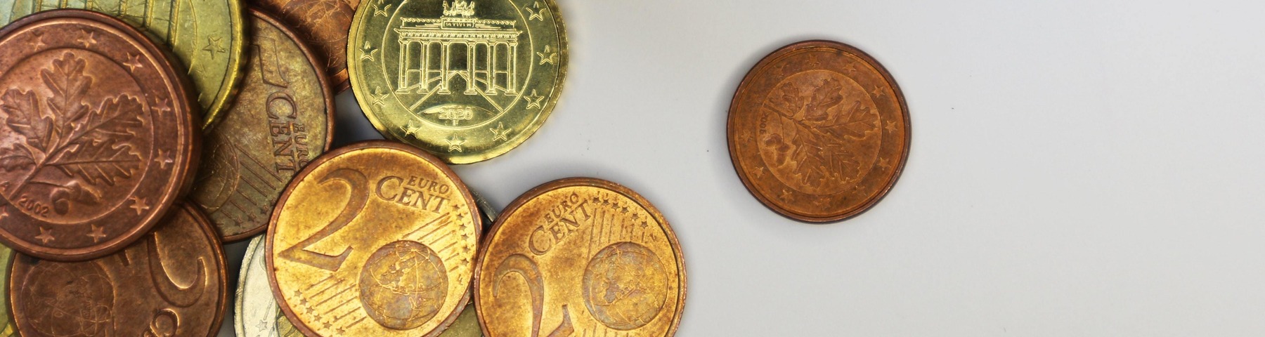 Euromünzen liegen auf einem weißen Tisch