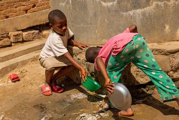 Kinder trinken aus sicherer Wasserquelle
